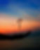 ethereal image of a leaf hovering over an upturned hand with a sunset background
